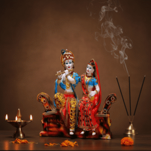 Handpainted 13-inch Radha Krishna polyresin idol statue sitting on a sofa for home mandir